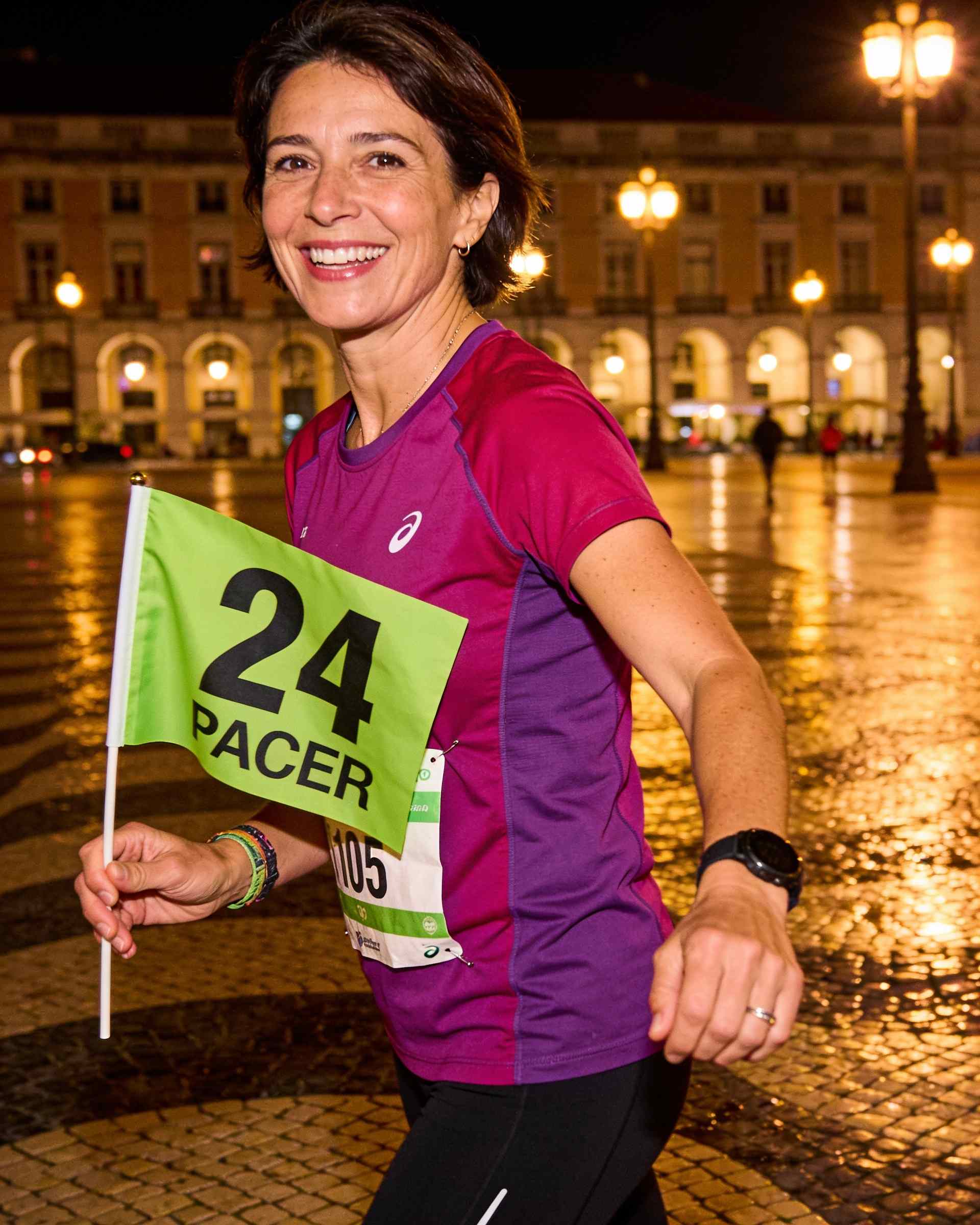 Marta Sousa, a runner, in Lisbon at night with a pacer flag
